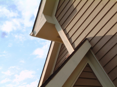 Close-up of a house with brown siding and beige trim