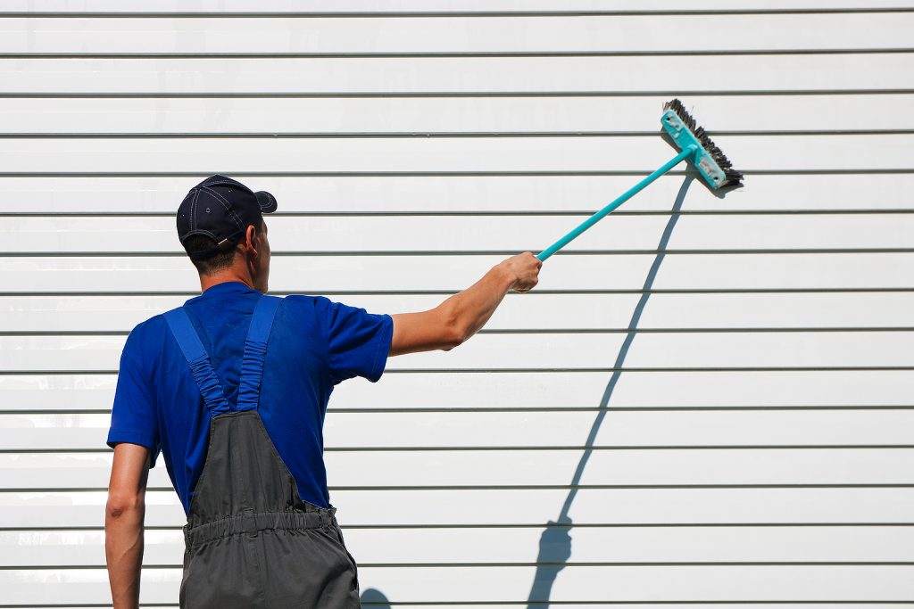 A worker brushes off finished siding