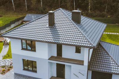 Aerial shot of a white house with dark roofing