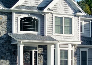 View of exterior of a gray house showing several windows