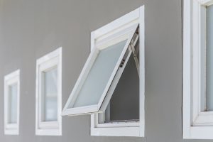 Four awning windows set in gray wall - one is open.